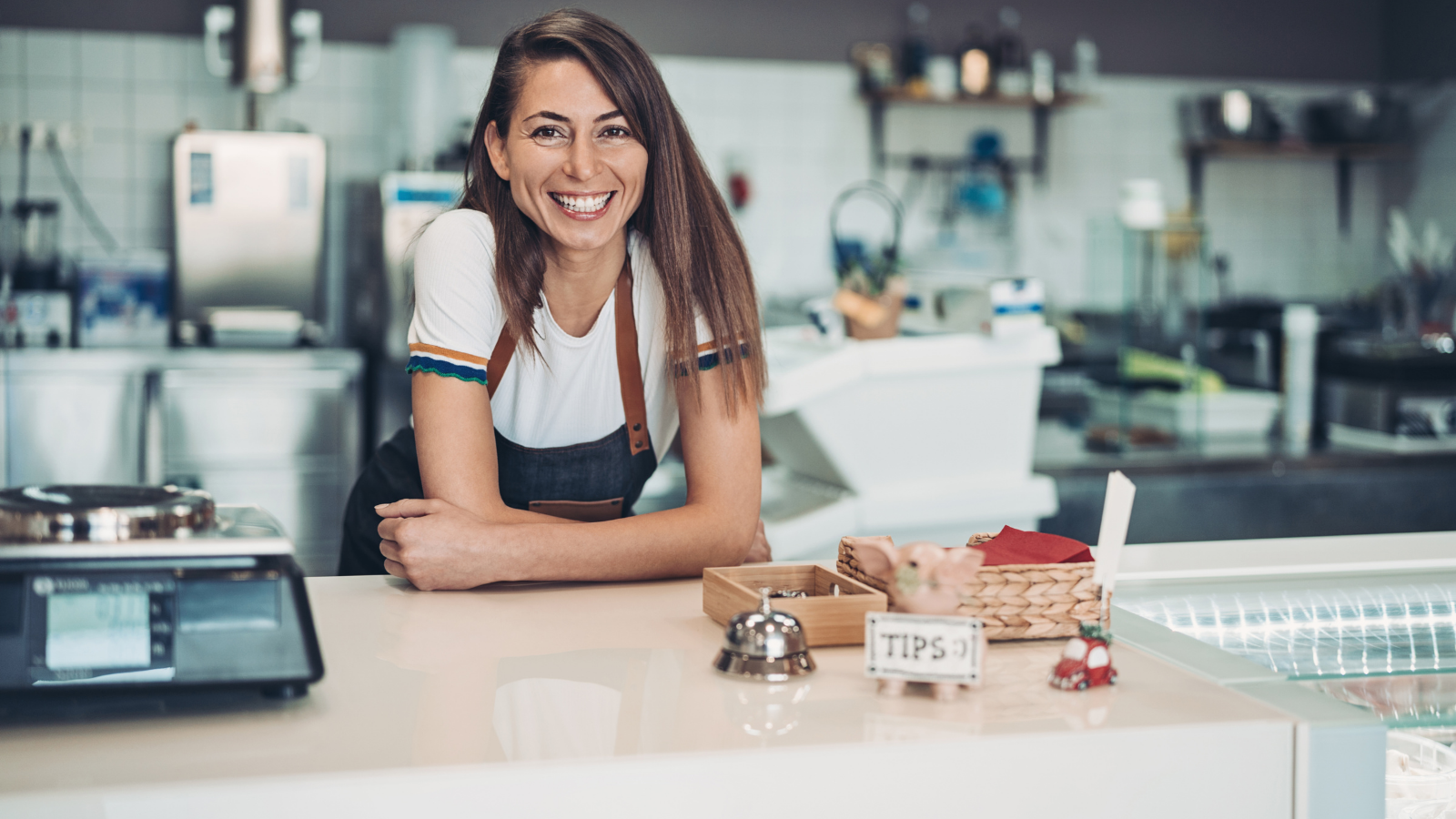 A small business owner sitting at a counter with a wide smile. Hot Dog Marketing