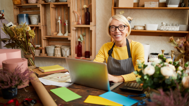 business-owner-smiling-at-laptop-researching-marketing-agencies